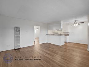Long Beach apartment for rent - A spacious room with wooden flooring and a ceiling fan.