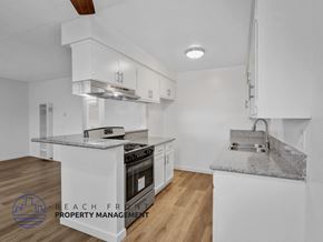 Long Beach apartment for rent - A modern kitchen with white cabinets and a granite countertop.