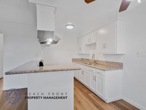 Long Beach apartment for rent - A kitchen with white cabinets and a granite countertop.
