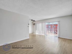 Inglewood apartment for rent - A spacious room with a ceiling fan and sliding glass doors.