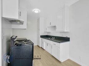Inglewood apartment for rent - A kitchen with white cabinets and a black stove top oven.