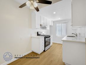 Downey apartment for rent - A kitchen with a stove top oven and a fan.