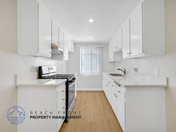 Downey apartment for rent - A kitchen with white cabinets and a wooden floor.