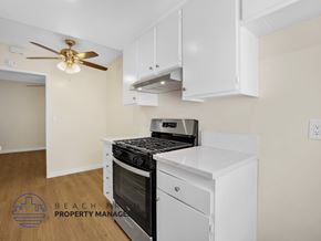 Downey apartment for rent - A kitchen with a stove top oven and a fan on the ceiling.