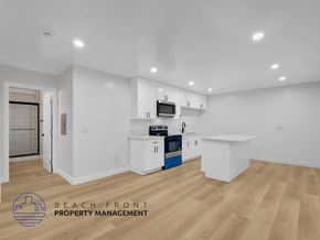 Long Beach apartment for rent - A kitchen with white cabinets and a wooden floor.