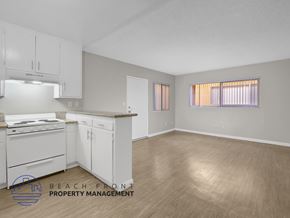 Long Beach apartment for rent - A kitchen with white cabinets and a wooden floor.