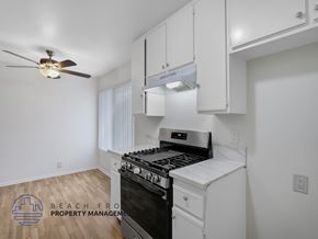 Harbor City apartment for rent - A kitchen with a stove top oven and a fan on the ceiling.