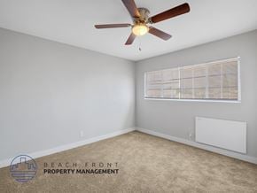 Long Beach apartment for rent - A room with a ceiling fan and a window with blinds.