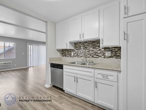 Long Beach apartment for rent - A kitchen with white cabinets and a stone backsplash.