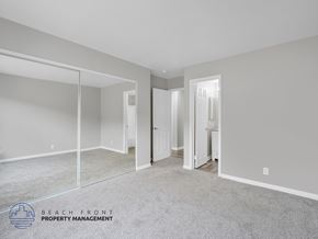 Long Beach apartment for rent - A spacious room with a carpeted floor and a mirror on the wall.