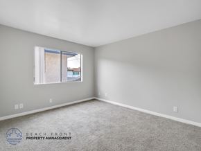 Long Beach apartment for rent - A room with a carpeted floor and a window showing a view of a building outside.