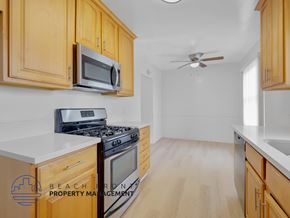 Los Angeles apartment for rent - A kitchen with wooden cabinets and a stove top oven.