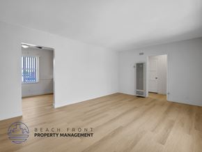 Los Angeles apartment for rent - A room with wooden flooring and white walls, with a window on the left and a door on the right.