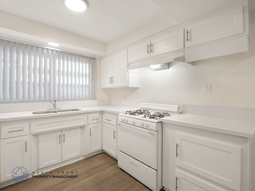 Inglewood apartment for rent - A white kitchen with a stove top oven and cabinets.