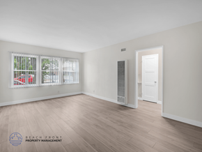 Los Angeles apartment for rent - A spacious room with wooden flooring and a window with blinds.
