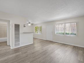 Long Beach apartment for rent - A spacious room with wooden flooring and a window with blinds.