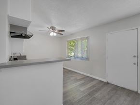 Long Beach apartment for rent - A room with a ceiling fan and a window with blinds.