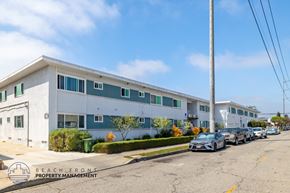 Hawthorne apartment for rent - A white and blue building with the words "Beach Front Property Management" on the bottom left corner.
