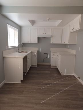 Hawthorne apartment for rent - an empty kitchen with white cabinets and a sink