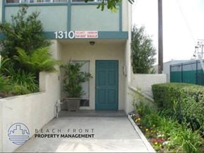 Wilmington apartment for rent - A green door is on the front of a building with a sign that says "BEACH FRONT PROPERTY MANAGEMENT".