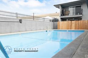 Norwalk apartment for rent - A pool with a fence and a building in the background.