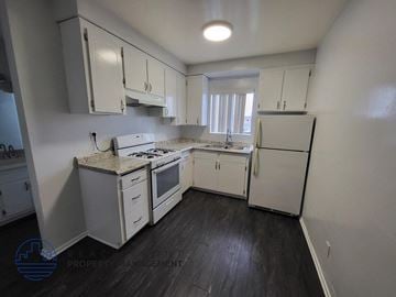Hawthorne apartment for rent - a white kitchen with white cabinets and a white refrigerator