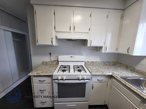 Hawthorne apartment for rent - A kitchen with a stove top oven and cabinets.