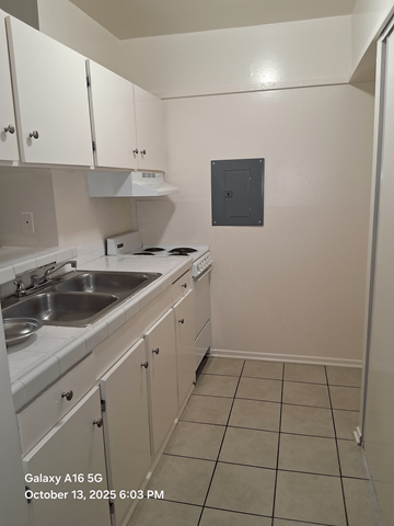 Lawndale apartment for rent - A kitchen with white cabinets and a white stove top oven.