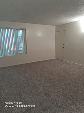 Lawndale apartment for rent - A room with a carpeted floor, a window with blinds, and a door.