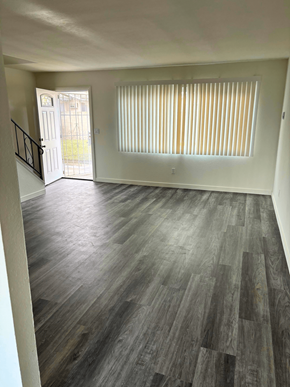 Santa Ana apartment for rent - an empty living room with wood flooring and a door to a balcony