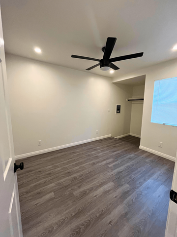 San Pedro apartment for rent - a living room with wooden floors and a ceiling fan