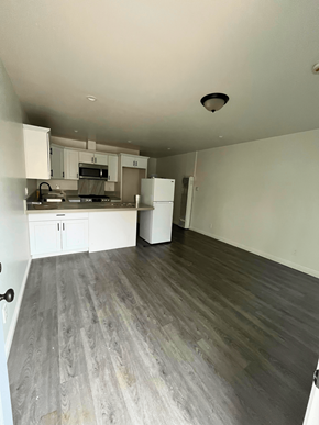 San Pedro apartment for rent - an empty living room and kitchen with wood flooring