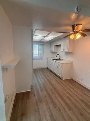Santa Ana apartment for rent - A room with a ceiling fan and wooden flooring.