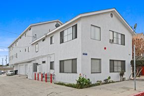 San Pedro apartment for rent - A white building with a blue sign on the front.