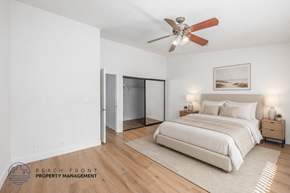 Hawthorne apartment for rent - A bedroom with a bed, a ceiling fan, and a nightstand with a lamp.