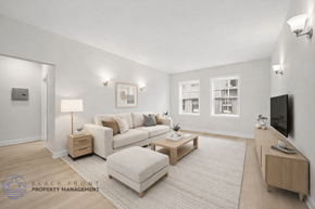Los Angeles apartment for rent - A well-lit living room with a white couch, a white ottoman, and a wooden coffee table.