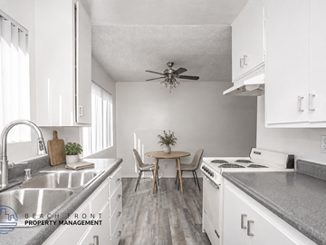 Torrance apartment for rent - A kitchen with white cabinets and a wooden table.