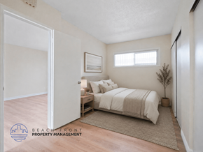 Torrance apartment for rent - A bedroom with a bed, nightstand, and a plant.