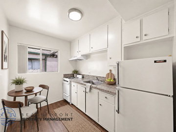 Hawthorne apartment for rent - A kitchen with white cabinets and a refrigerator.