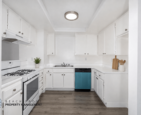 Hawthorne apartment for rent - A kitchen with white cabinets and a blue dishwasher.