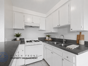 Hawthorne apartment for rent - A kitchen with white cabinets and a black countertop.