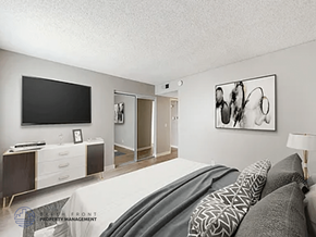 Paramount apartment for rent - A modern bedroom with a large bed and a television.