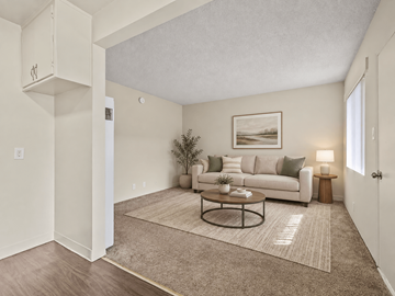 Wilmington apartment for rent - A living room with a couch, a plant, and a painting on the wall.