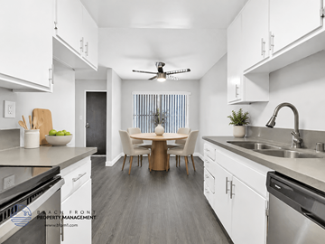 Inglewood apartment for rent - A modern kitchen with white cabinets and a dining area with a table and chairs.