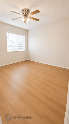 La Habra apartment for rent - A room with a ceiling fan and wooden flooring.