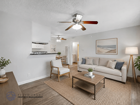 Downey apartment for rent - A living room with a ceiling fan, a couch, a chair, and a coffee table.