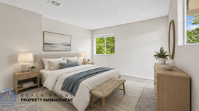 Santa Ana townhouse for rent - A well-lit bedroom with a large bed and a wooden nightstand.