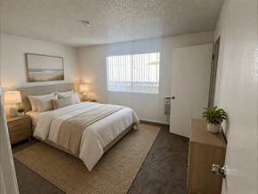Wilmington apartment for rent - A bedroom with a large bed and a window with blinds.