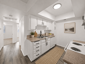 Long Beach apartment for rent - A kitchen with white cabinets and a brown rug.