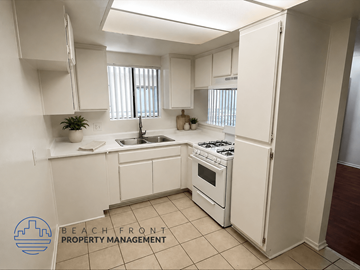Wilmington apartment for rent - A kitchen with white cabinets and appliances, a sink, and a stove top oven.